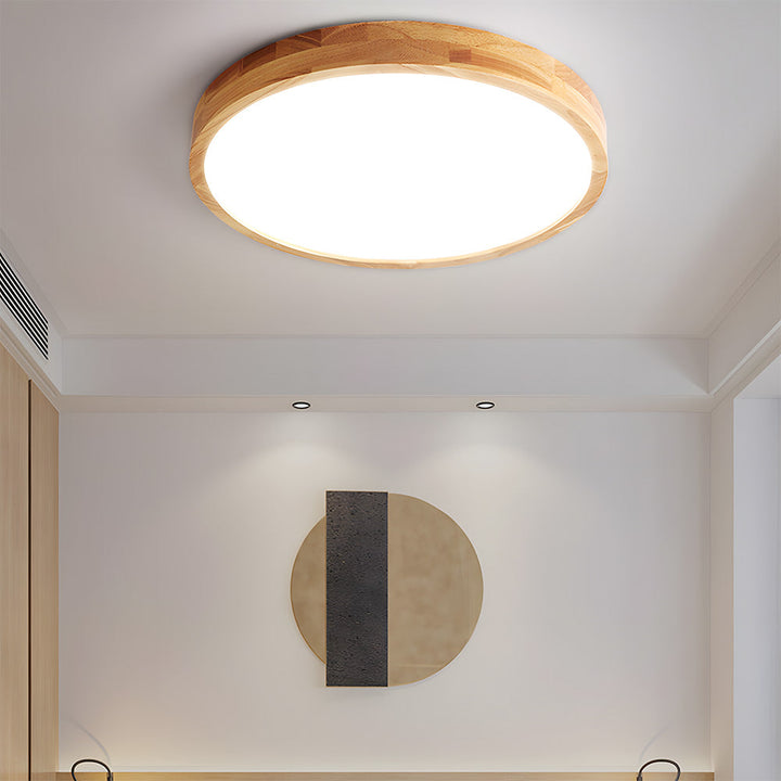 Minimalist wood ceiling lamp with acrylic diffuser over a dining table