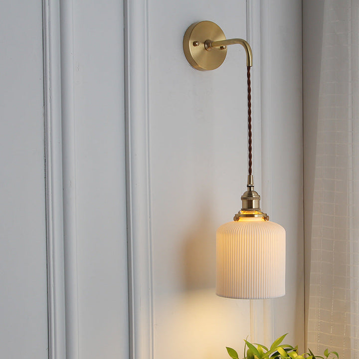Japanese brass pleated glass wall light on a straight arm in a refined dining room