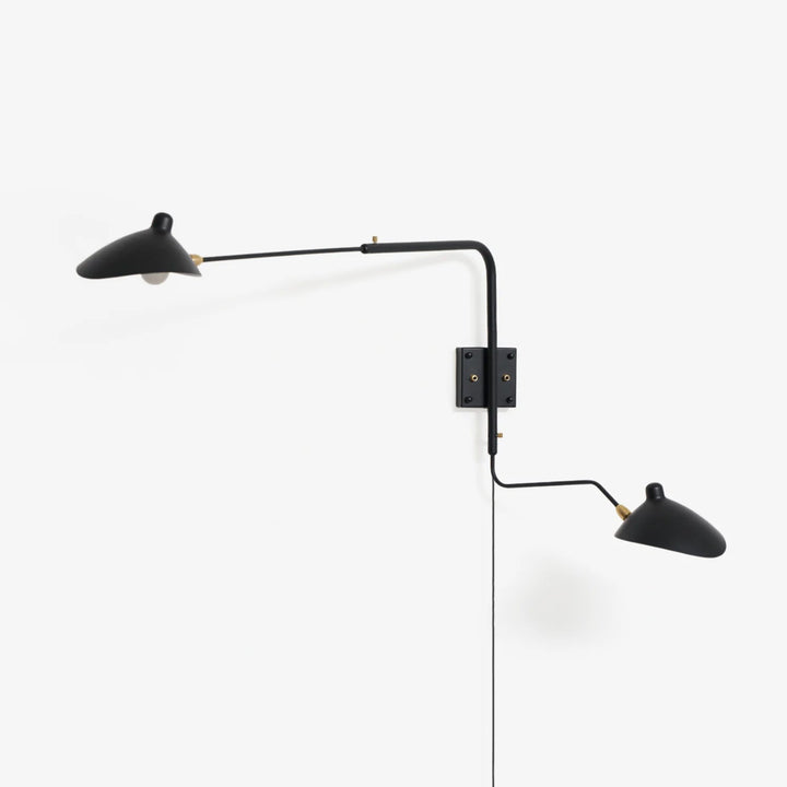 Versatile Arm Wall Sconce in matte black mounted on a feature wall above a sofa