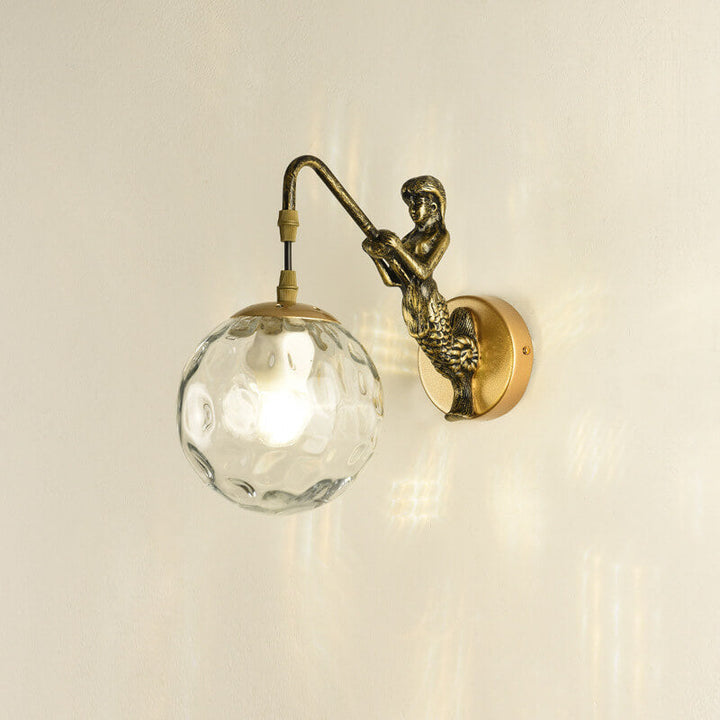 Mermaid wall sconce installed in powder room beside mirror