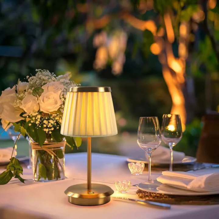 Pollux classic LED table lamp glowing warmly on a bedside table