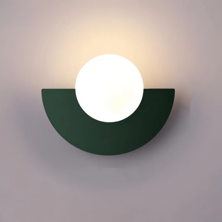 Black-frame tri-colour glass globe LED wall sconce above a bedside table