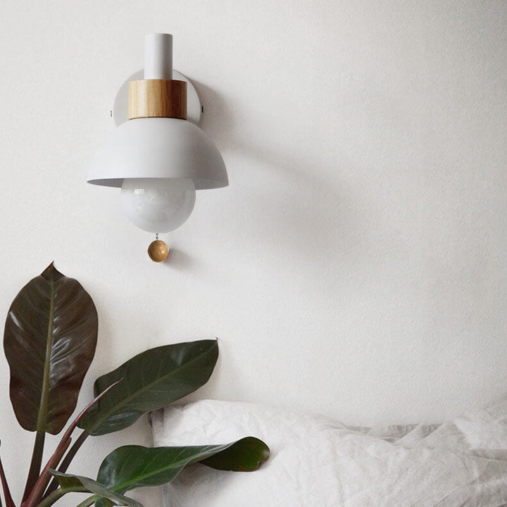 Wood-and-metal wall light in a guesthouse bedroom