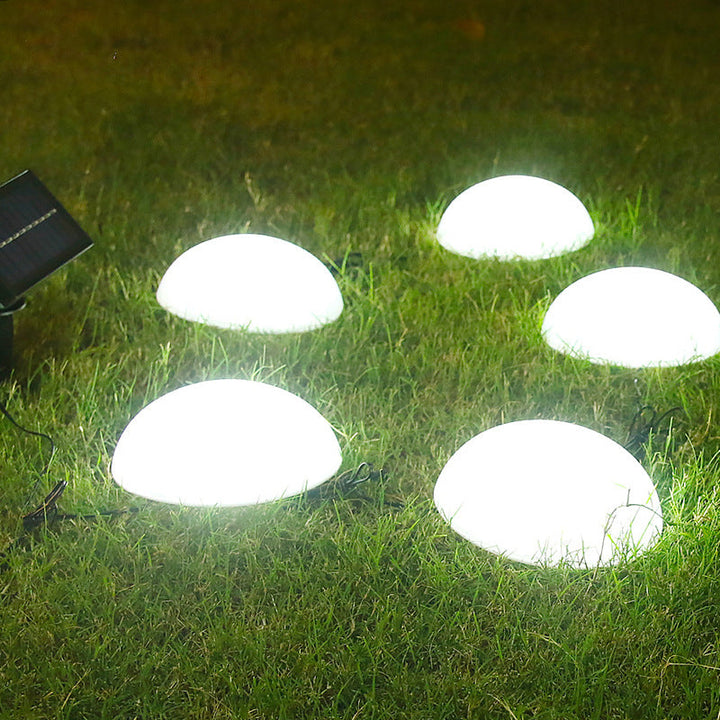 Solar LED garden light illuminating garden pathway at dusk