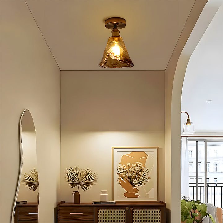 Vintage brass ceiling lamp side view showing curved amber glass shade