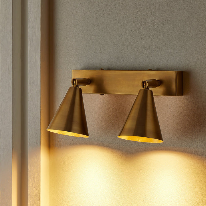 Twin adjustable brass spotlight heads on slim wall plate