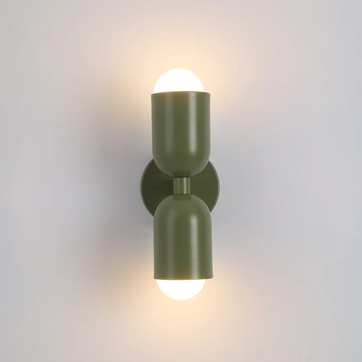 Colorwave LED metal cylinder wall sconce in green, casting up-down light on a modern wall