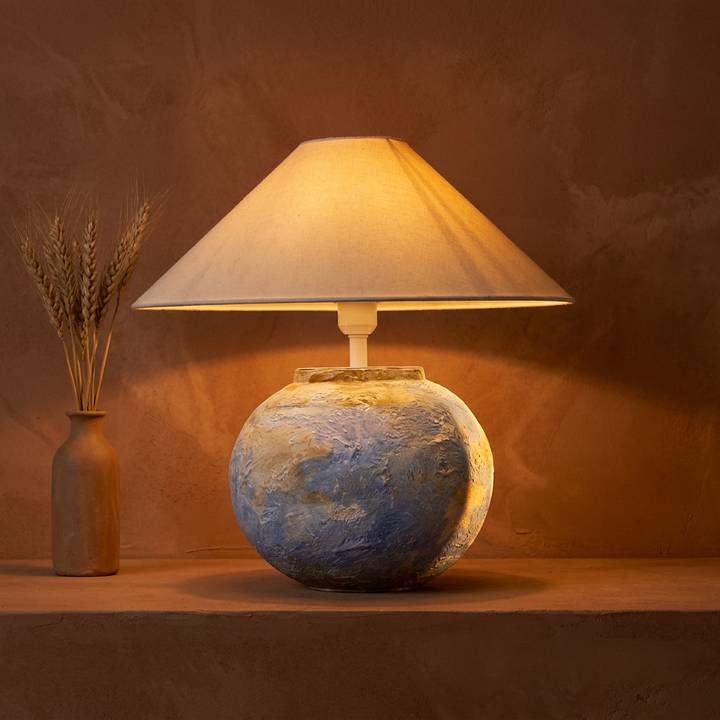 Aurellore watercolour terracotta ceramic table lamp glowing warm with sunset rim light, hero shot