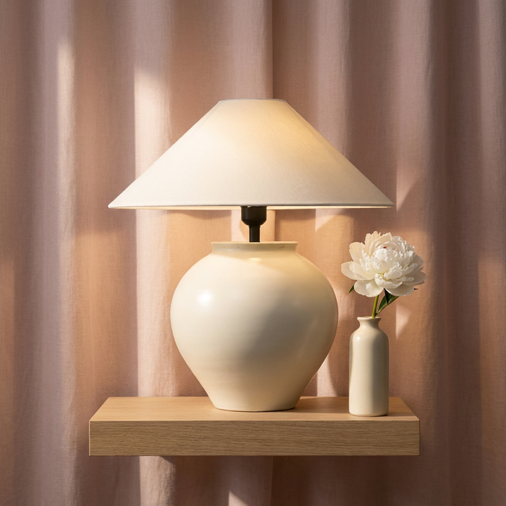 Lumora organic earthenware ceramic table lamp with dawn pink linen drape and morning light, hero shot
